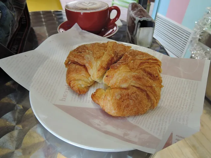 Croissant mit Kaffeebohnen auf einem Teller