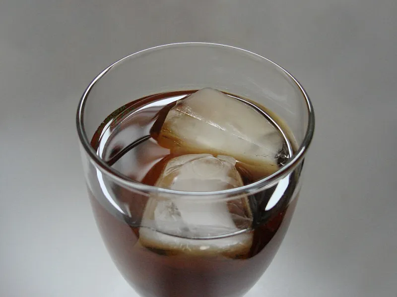 Glas schwarzer Eistee mit Eiswürfeln
