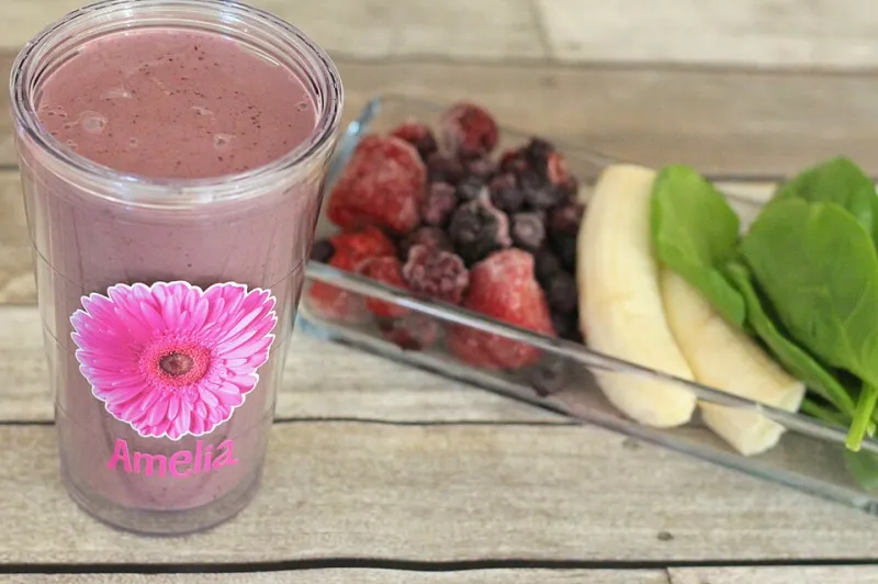 Beeren-Smoothie im Glas mit Blütenblättern